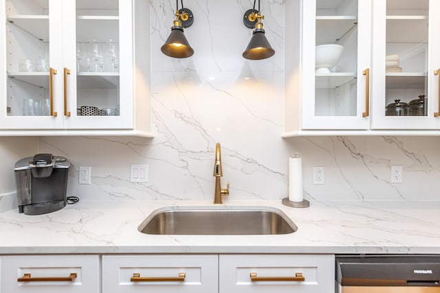 kitchen with sink, dishwashing machine, white cabinets, and tasteful backsplash