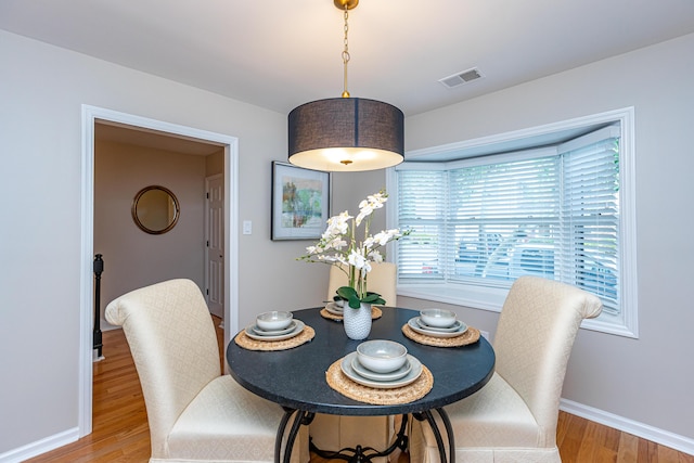 dining space with wood-type flooring