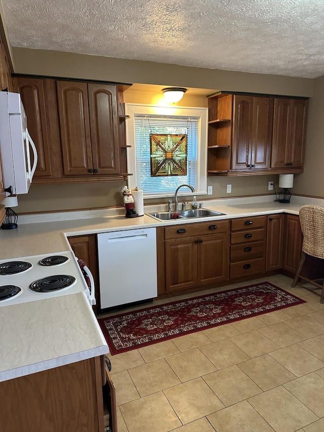 kitchen with sink, a textured ceiling, and white appliances