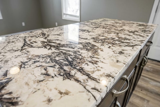 room details with dark wood-type flooring and light stone counters