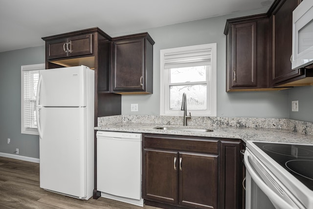 kitchen featuring plenty of natural light, sink, dark wood-type flooring, and white appliances