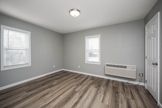 unfurnished bedroom with dark hardwood / wood-style flooring and a wall mounted AC