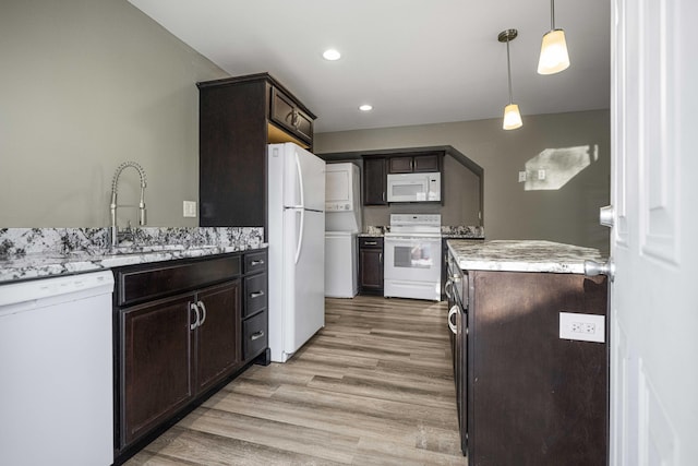 kitchen with sink, dark brown cabinets, hanging light fixtures, light hardwood / wood-style flooring, and white appliances