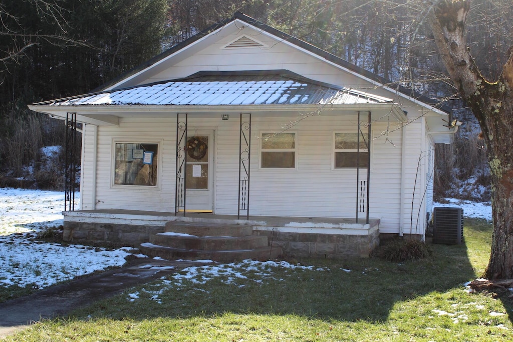 bungalow-style house with central AC unit and covered porch