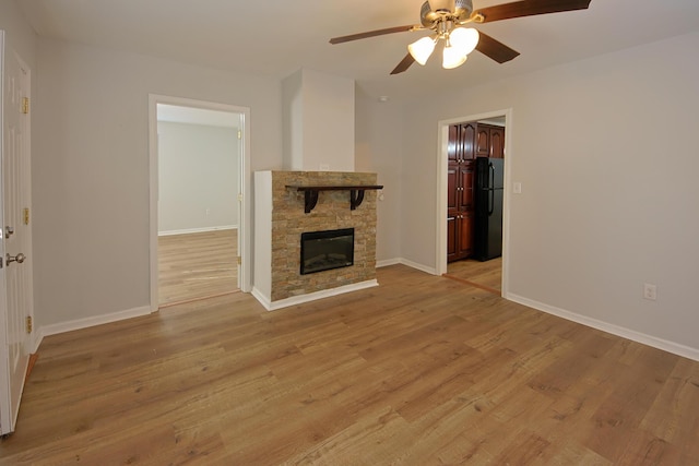 unfurnished living room featuring a fireplace, light wood-type flooring, and ceiling fan