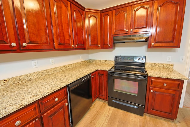 kitchen featuring light stone counters, light hardwood / wood-style floors, and black appliances