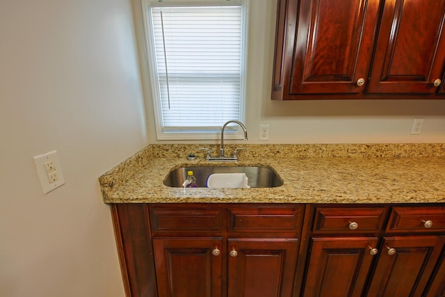 kitchen with light stone countertops and sink