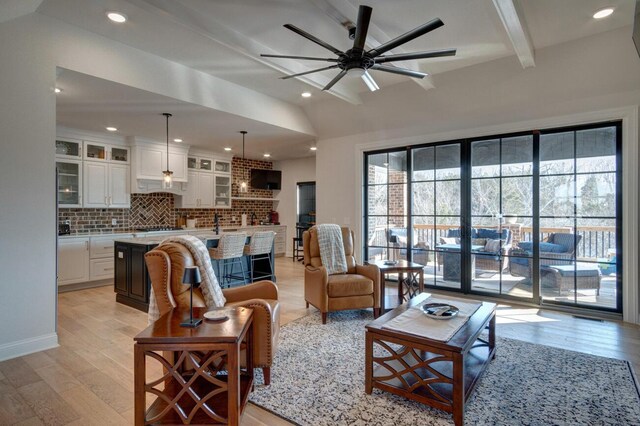 carpeted living area with a stone fireplace, recessed lighting, baseboards, and ornamental molding