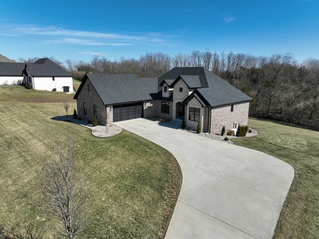 french country home featuring driveway, brick siding, and a front yard