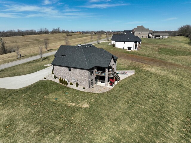 view of front of property with brick siding, a shingled roof, a front lawn, concrete driveway, and an attached garage