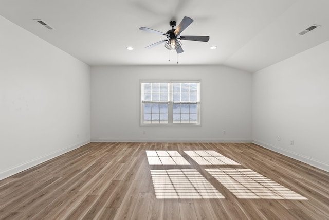 unfurnished room with ceiling fan, vaulted ceiling, and light wood-type flooring