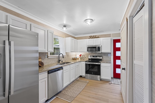 kitchen featuring white cabinetry, stainless steel appliances, light hardwood / wood-style floors, sink, and light stone counters