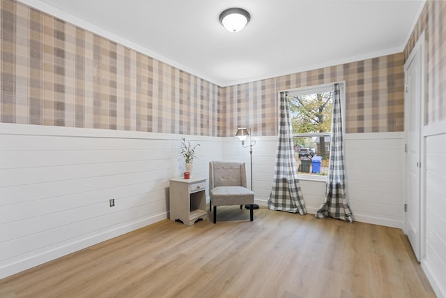 living area featuring light wood-type flooring and crown molding