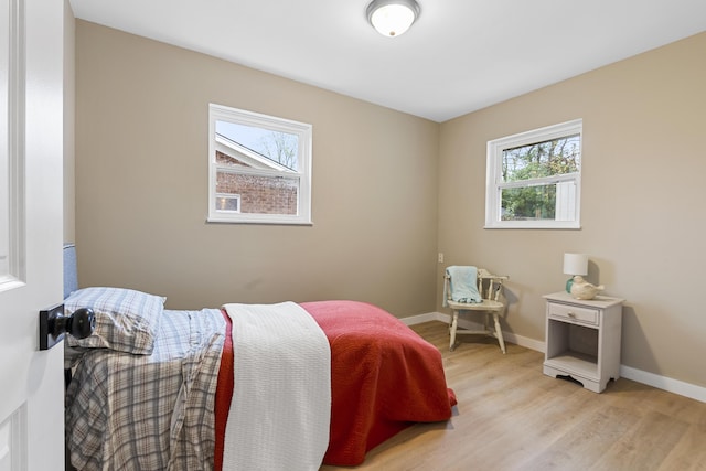 bedroom featuring multiple windows and light hardwood / wood-style flooring