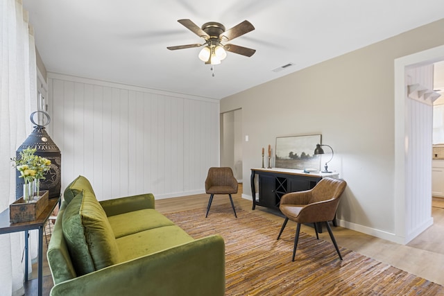 living room with ceiling fan and light hardwood / wood-style flooring