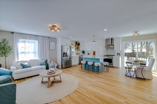 living room with a wealth of natural light and light hardwood / wood-style flooring