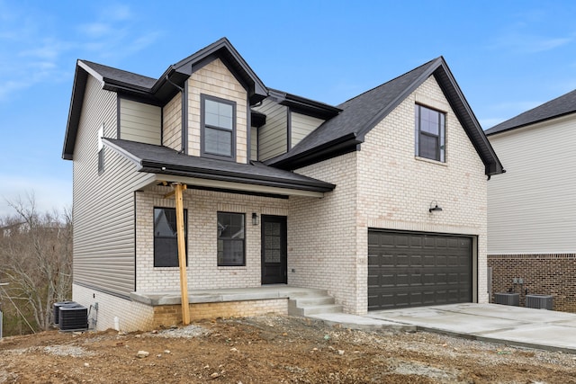 view of front facade featuring concrete driveway, an attached garage, central air condition unit, a porch, and brick siding