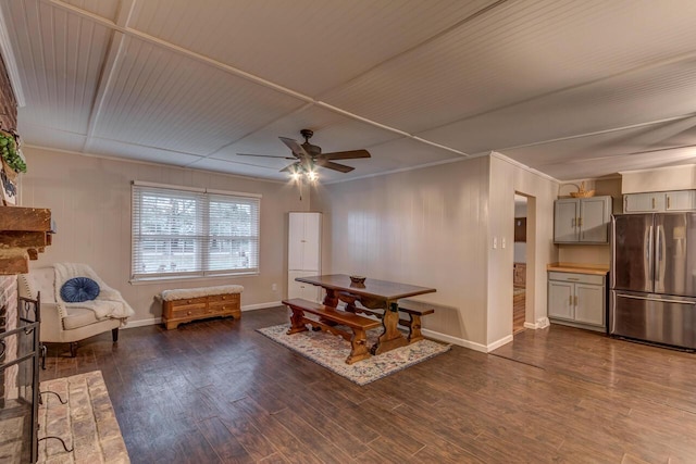 dining space featuring ceiling fan, dark hardwood / wood-style floors, and a brick fireplace