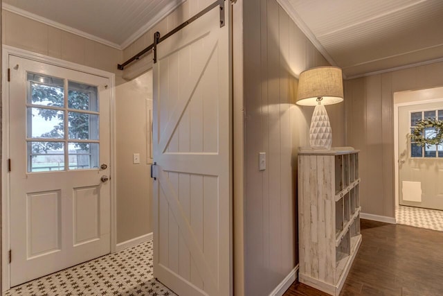 doorway featuring a barn door, wooden walls, and ornamental molding