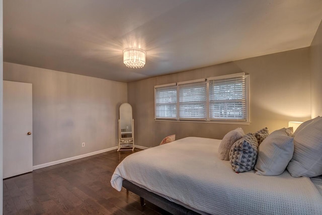 bedroom featuring dark hardwood / wood-style floors and a notable chandelier