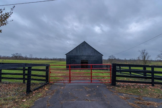 view of gate with an outbuilding and a rural view