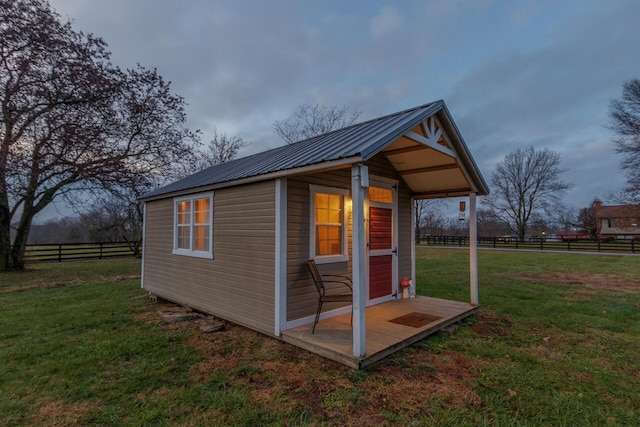 view of outdoor structure with a rural view and a lawn