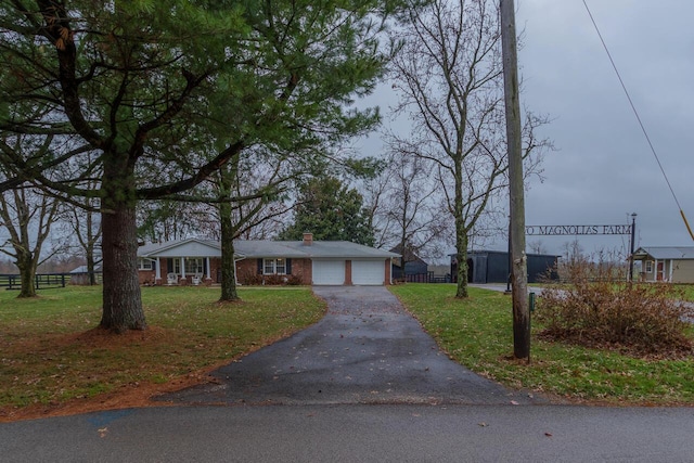 single story home featuring a front lawn and a garage