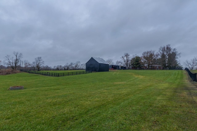 view of yard with a rural view and an outdoor structure