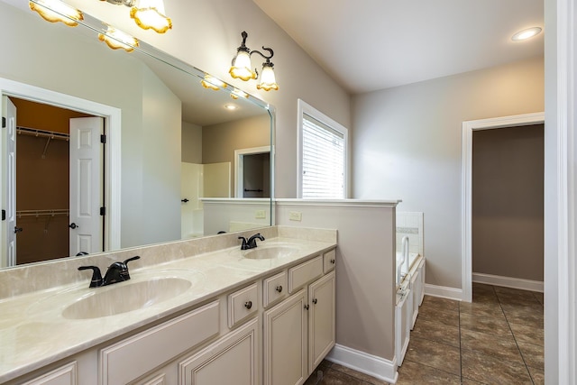 bathroom with a washtub, tile patterned flooring, and vanity