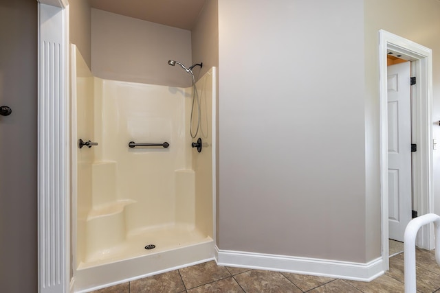 bathroom with a shower and tile patterned flooring