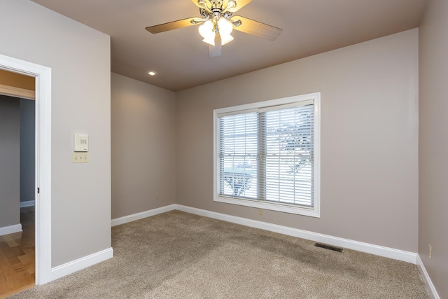 spare room with ceiling fan and light colored carpet