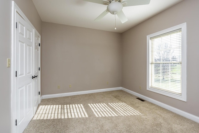 unfurnished room featuring ceiling fan and light carpet