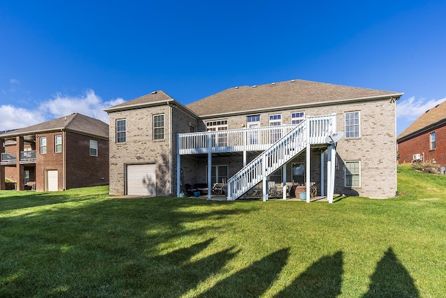 rear view of property featuring a deck, a lawn, and a garage