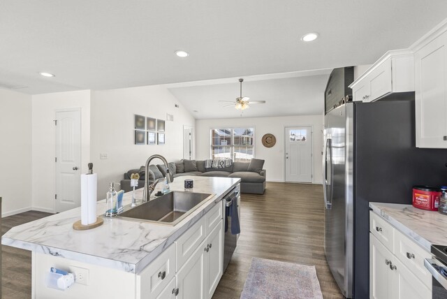 kitchen with white cabinetry, stainless steel appliances, an island with sink, sink, and a breakfast bar area