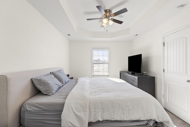 bedroom featuring ceiling fan and a tray ceiling