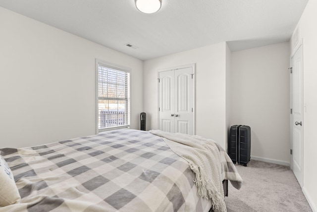 bedroom featuring a closet and light colored carpet