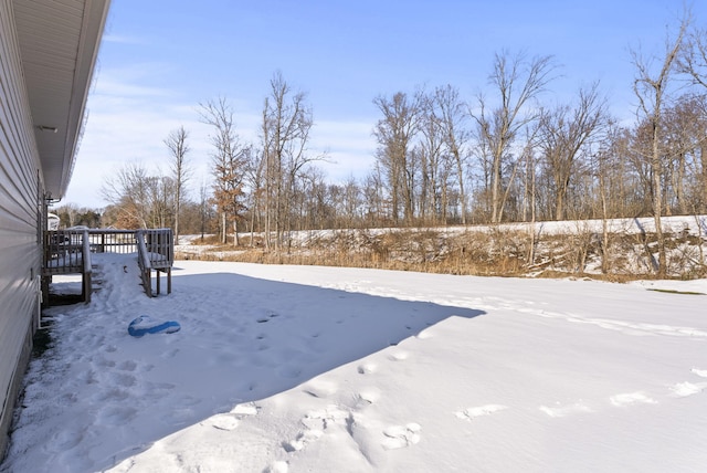 yard layered in snow featuring a wooden deck