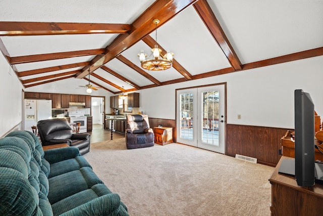 living room with carpet floors, french doors, lofted ceiling with beams, and a notable chandelier