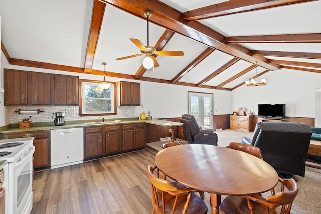 kitchen with decorative light fixtures, backsplash, vaulted ceiling with beams, white appliances, and french doors