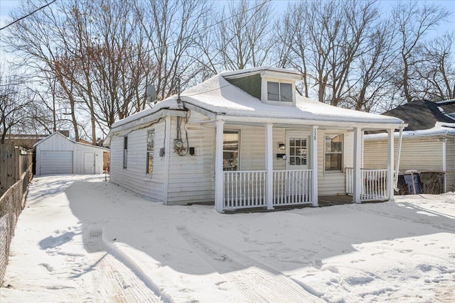 bungalow with covered porch, an outbuilding, and a garage