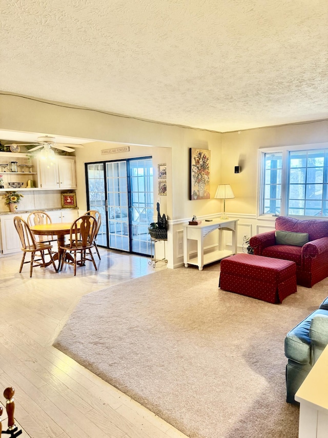 living room featuring ceiling fan and a textured ceiling