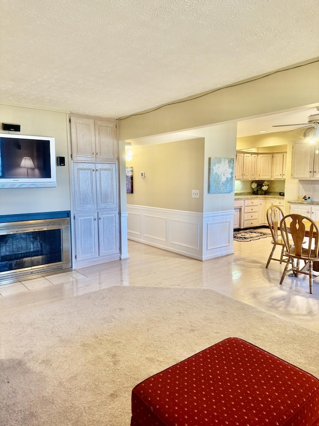 living room with ceiling fan and a textured ceiling