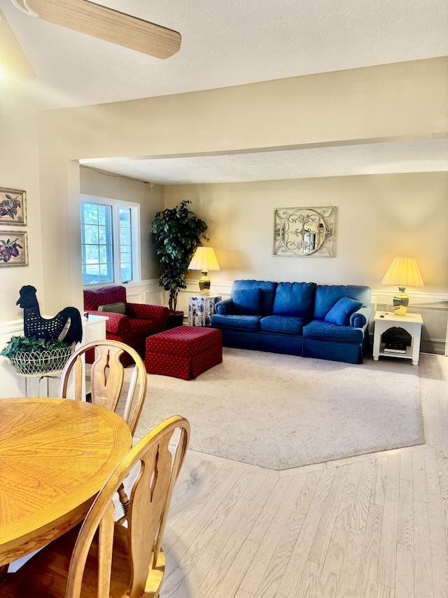 living room with ceiling fan and wood-type flooring