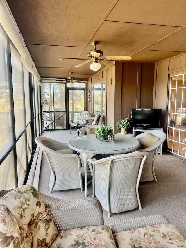 sunroom featuring ceiling fan, wood ceiling, and a healthy amount of sunlight