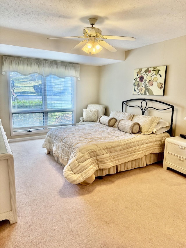 bedroom featuring a textured ceiling, ceiling fan, and carpet flooring