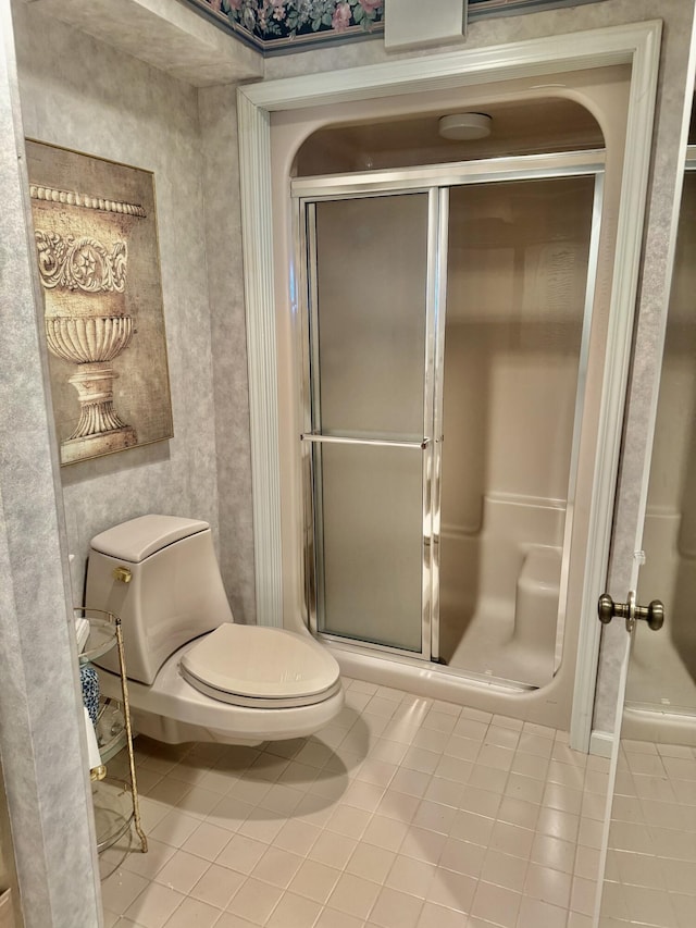 bathroom with toilet, tile patterned floors, and a shower with door