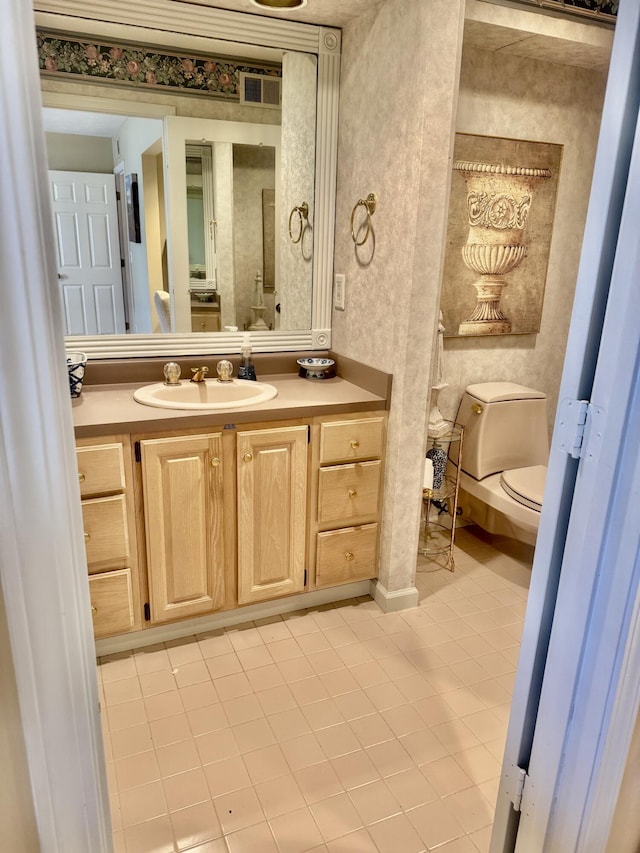 bathroom with toilet, tile patterned flooring, and vanity