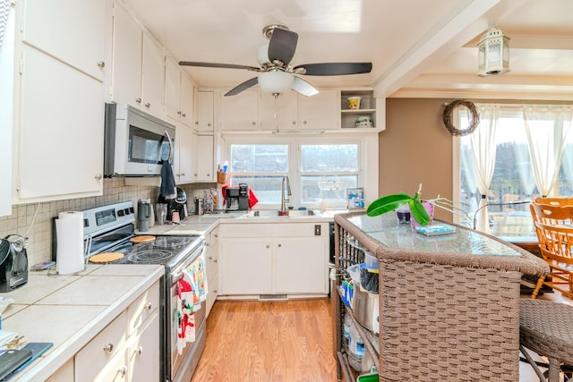 kitchen featuring sink, stainless steel appliances, light hardwood / wood-style floors, and white cabinets