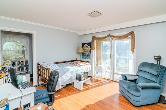 interior space with multiple windows, hardwood / wood-style floors, access to outside, and ornamental molding