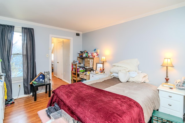 bedroom featuring multiple windows, ornamental molding, and light hardwood / wood-style floors